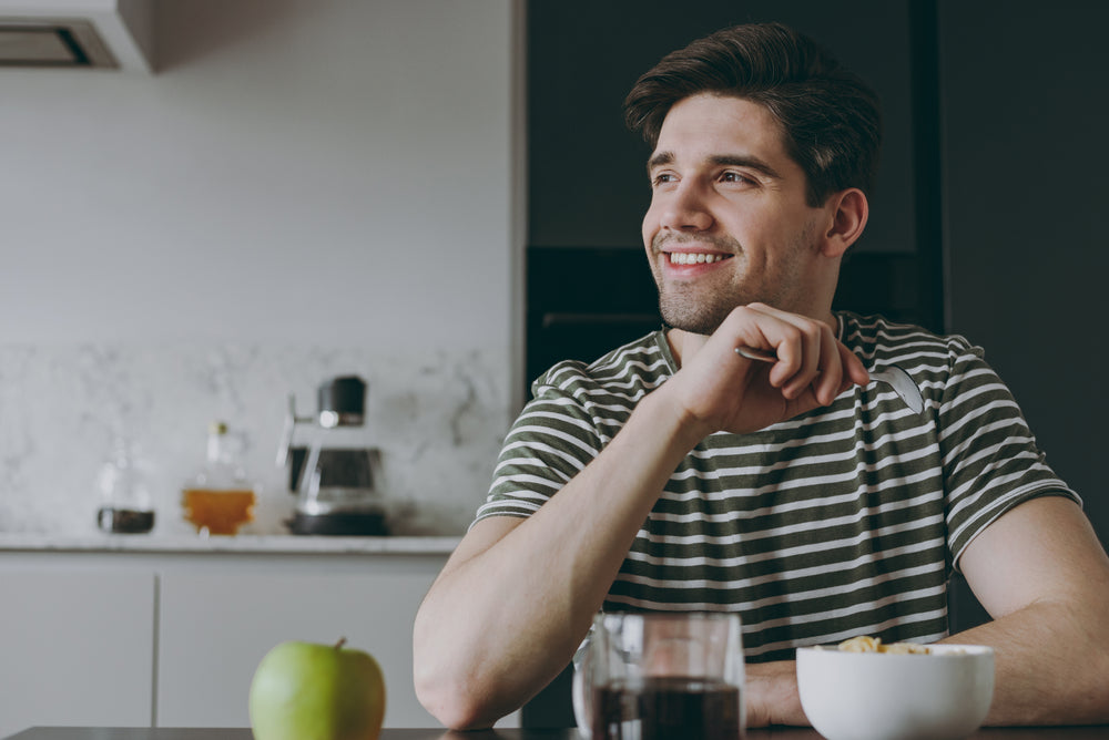 A happy man in his 30s about to eat a healthy breakfast of oats